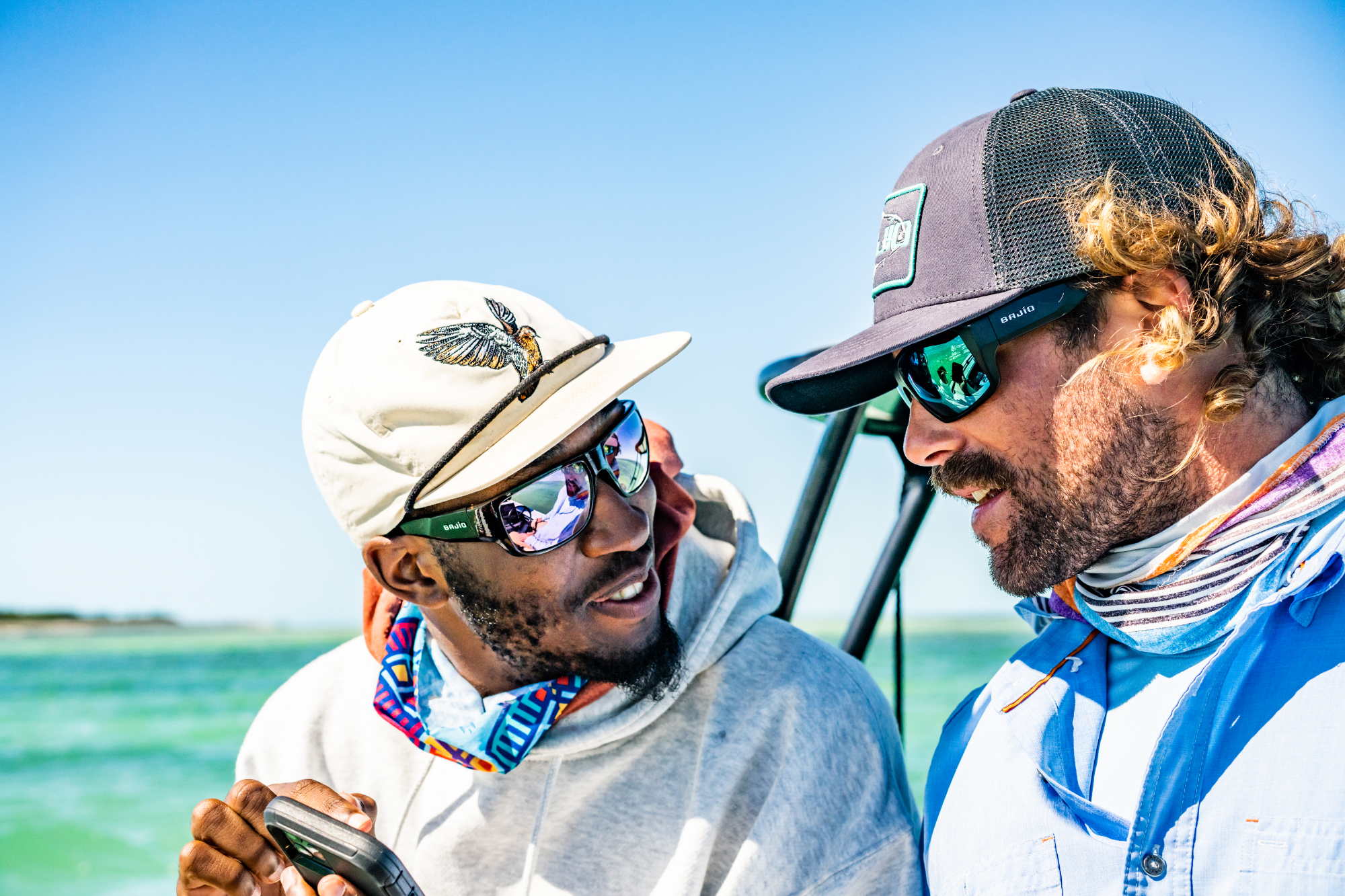 Two men wearing Bajio fishing sunglasses on a boat in the ocean