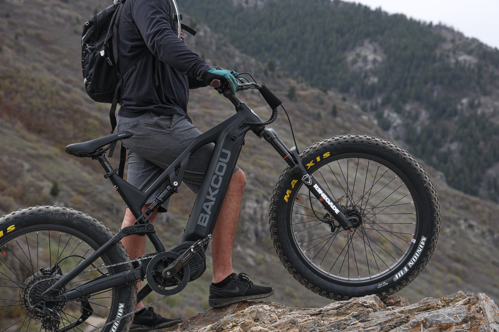 Bakcou Scout Electric Bike in Matte Black with man climbing rocky terrain