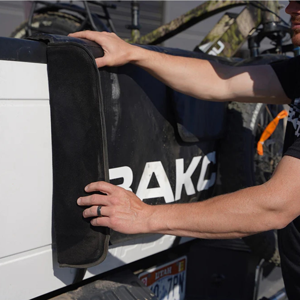 Close-up view of the Bakcou Extendable Tailgate Pad on a truck, showing weatherproof nylon construction and protective soft backing.