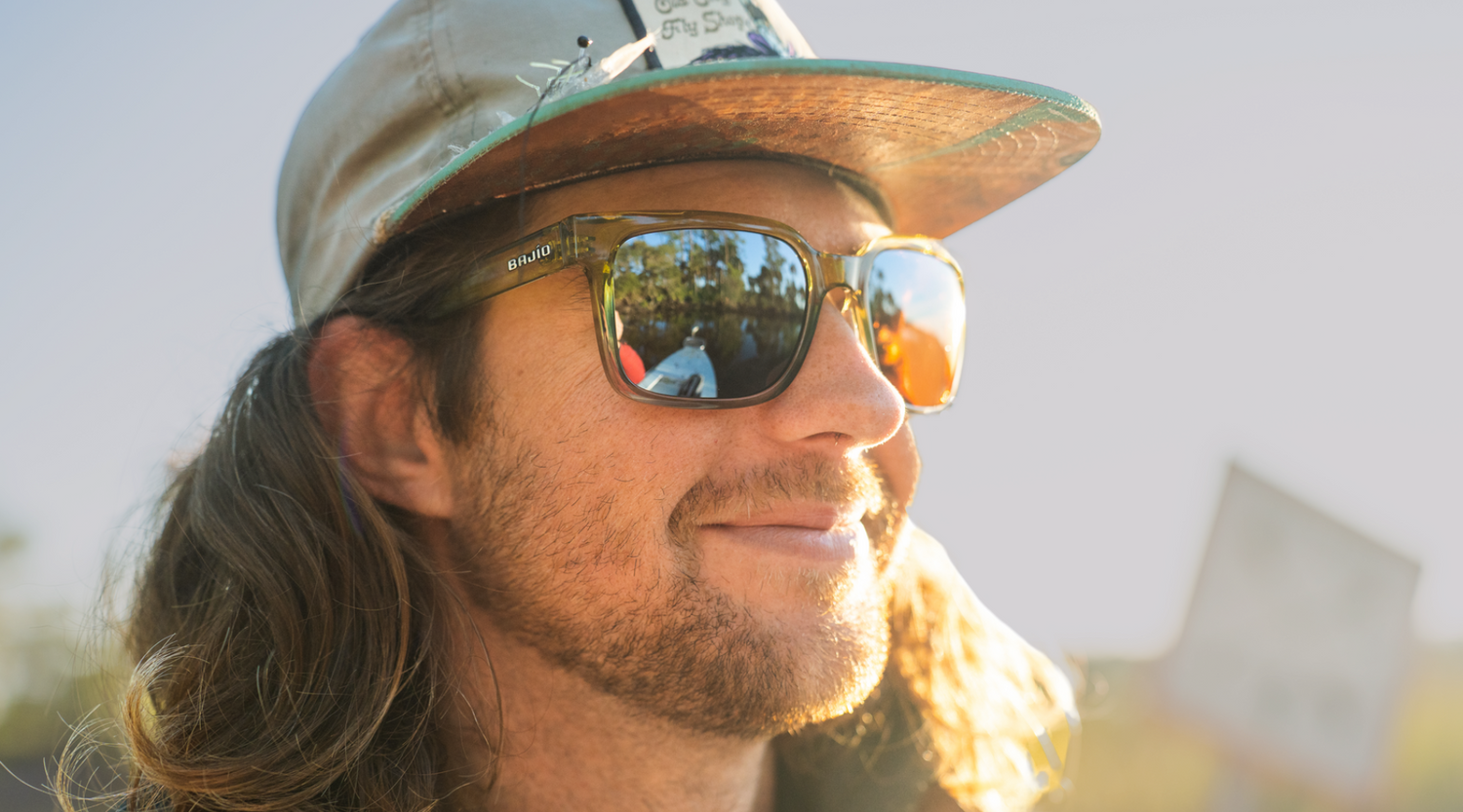 Fisherman wearing Bajío Sunglasses with Silver Mirror Lenses by a river – Polarized Fishing Glasses for Medium Light