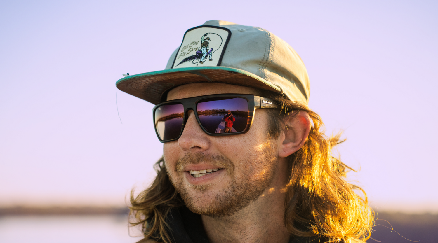 Man wearing Bajío Sunglasses with Violet Mirror Lenses at sunrise – High-Contrast Sunglasses for Low Light Conditions