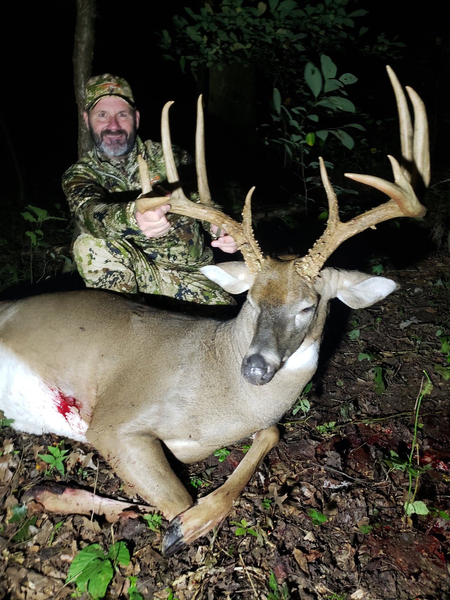 Chuck Main with harvested whitetail buck on managed hunting property