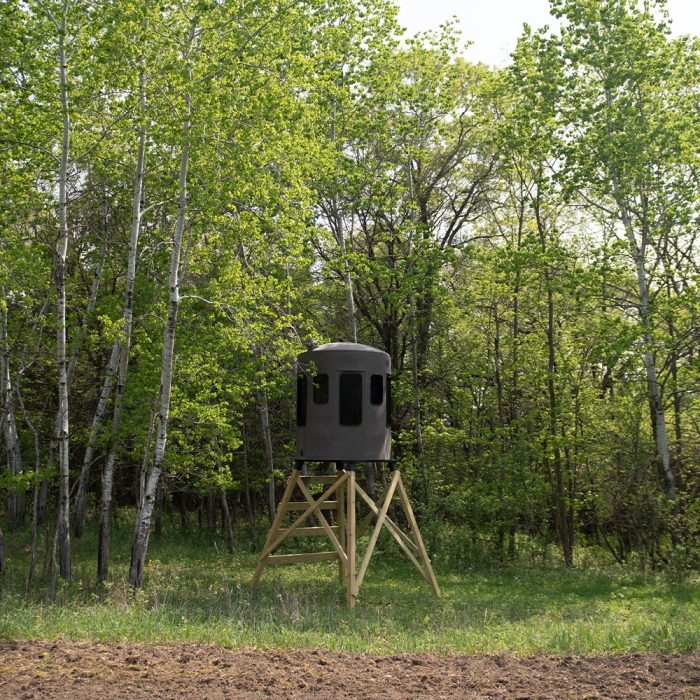 Lifestyle image of the Stump hunting blind in the woods on supports