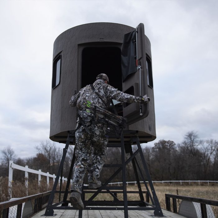Man climbing inside the Stump 4 hunting blind