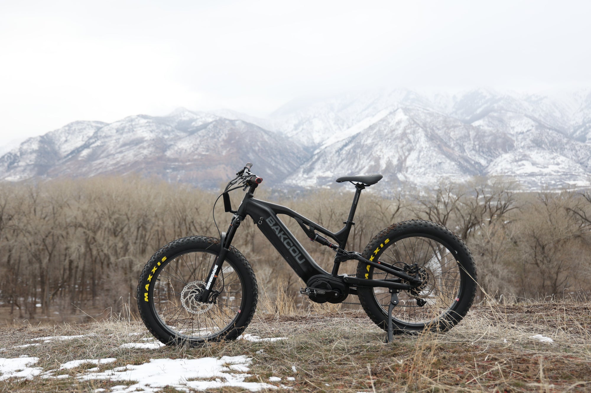 Bakcou Scout electric bike in matte black, side view, on trail in the mountains